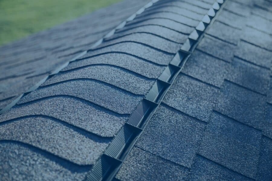 Close-up view of a shingle-over ridge vent installed along the peak of an asphalt shingle roof.