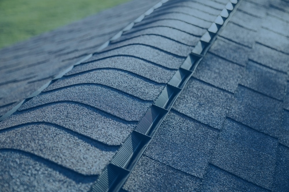 Close-up view of a shingle-over ridge vent installed along the peak of an asphalt shingle roof.