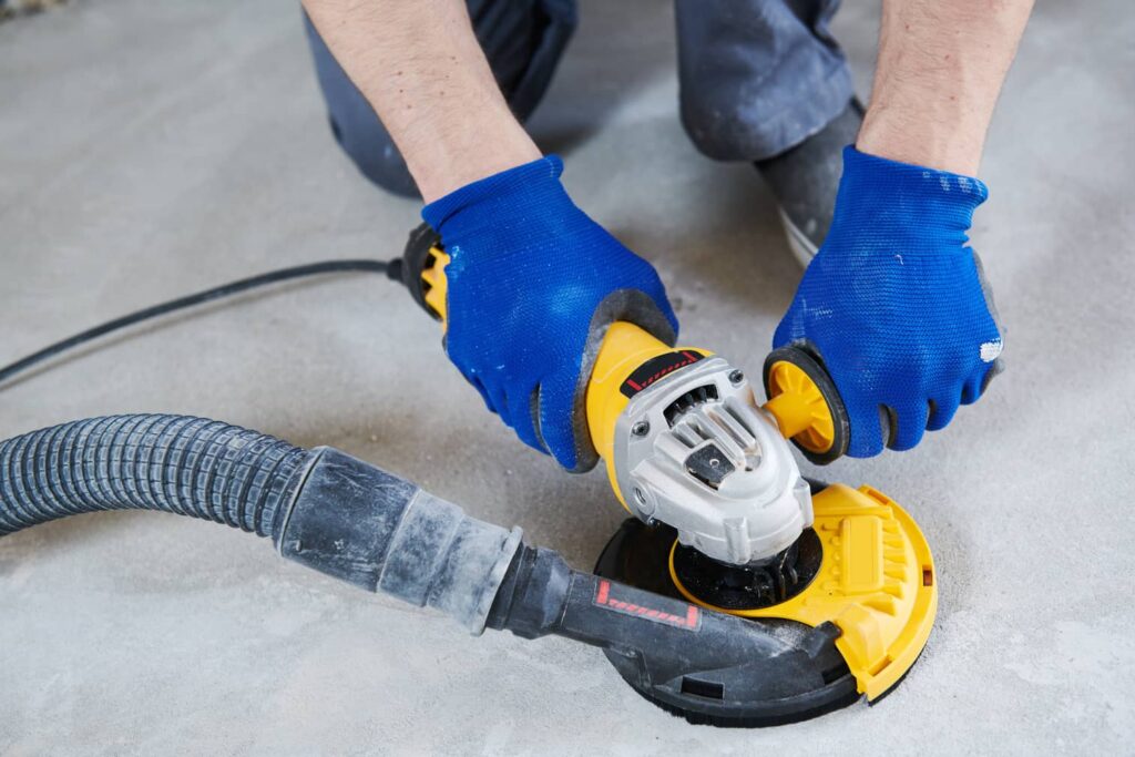 Once all of the glue is removed from the concrete, you can sand it down for a smooth surface.